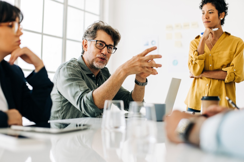 Man talking in an intense office meeting managing stress successfully