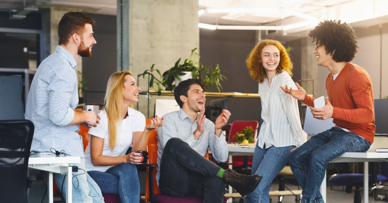 Happy team working together where DEI strategies are imbedded in the culture.